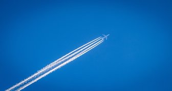 Airplane flying across a blue sky, leaving contrails—symbolizing pilot Jack’s free flights and coverage for _The Courier_