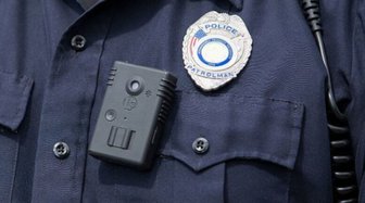 Body camera and police badge on a uniform, illustrating Sheriff Mack’s request for increased surveillance technology
