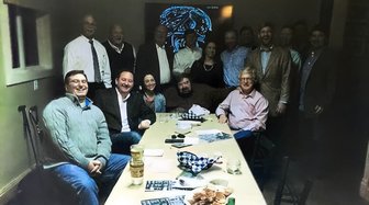 Group gathered around a table, possibly members of CATALYST, a Baldwin County political group discussed in the article