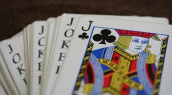 Stack of playing cards, including a Jack of Clubs, symbolizing complex corporate structures and potential concealment