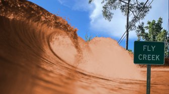 Muddy wave cresting near a “Fly Creek” sign, illustrating infrastructure failures impacting the creek with sediment runoff