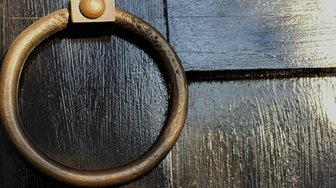 Door knocker on a weathered door, symbolizing persistent effort needed for success despite potential rejection