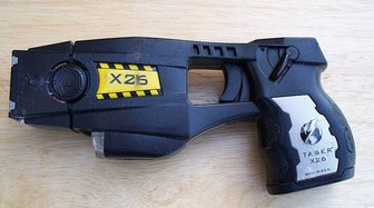 Taser X26 device shown; highlights lack of non-lethal equipment acquisition by Baldwin County police departments