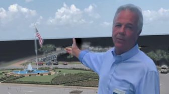 Former BP executive gestures toward a fountain in Fairhope, Alabama, amid criticism over his role in the Mobile Bay cleanup