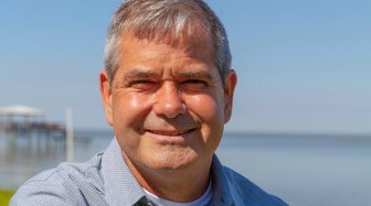 Matt McKenzie, newly elected Baldwin County Commissioner, smiles against a waterfront backdrop